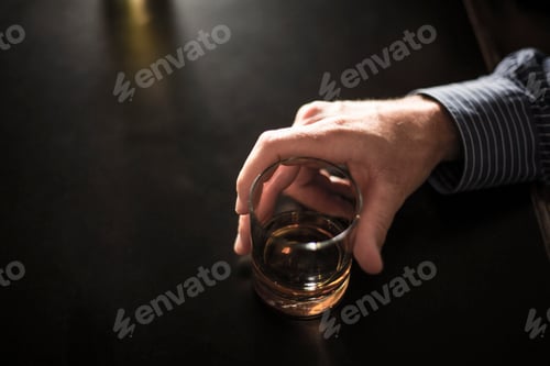 Preview: Close up of solitary man with drink in bar
