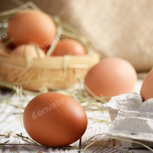 Preview: Raw organic brown chicken eggs in square wicker basket on white
