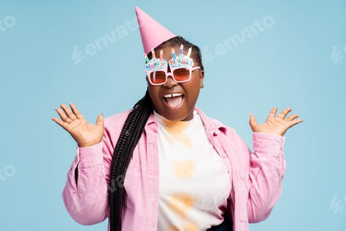 Preview: Excited African American woman wearing stylish party eyeglasses, birthday cone looking at camera