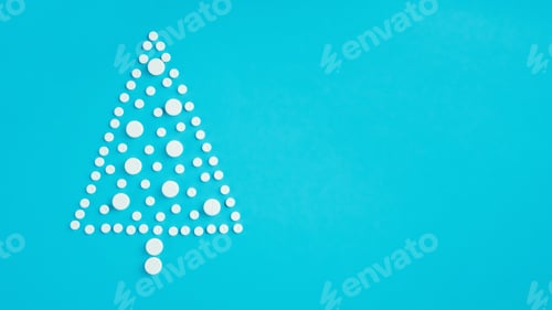 Preview: White round pills, laid out in shape of Christmas tree on light blue background. Banner. Flat lay