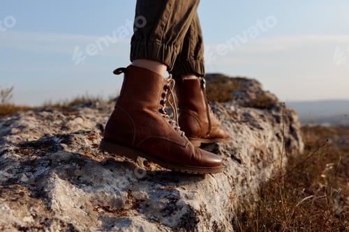 Preview: Person standing on top of rock with sun in background on adventure trip exploring nature and beauty