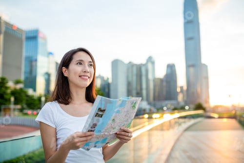 Preview: Woman using city map in Hong Kong city during sunset