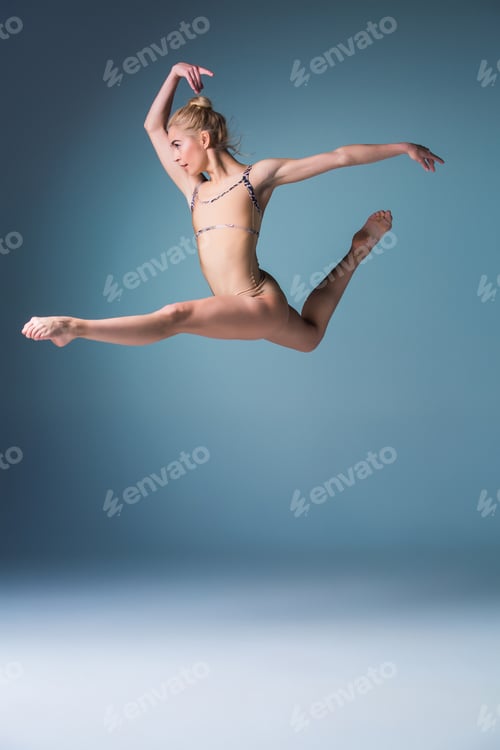 Preview: Young beautiful modern style dancer jumping on a studio background