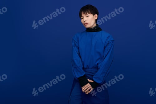 Preview: Captivating presence of a young handsome asian man against a blue background