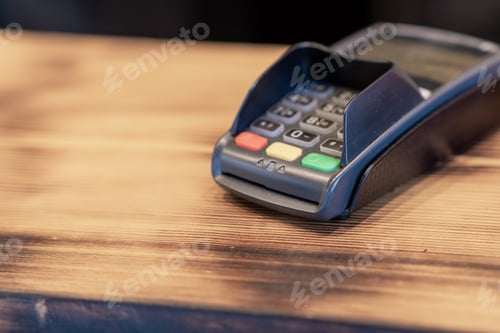 Preview: Terminal for cashless payment on a wooden background in a cafe