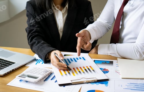 Preview: Asian businesswoman or accountant working pointing graph discussion and analysis data charts and gra