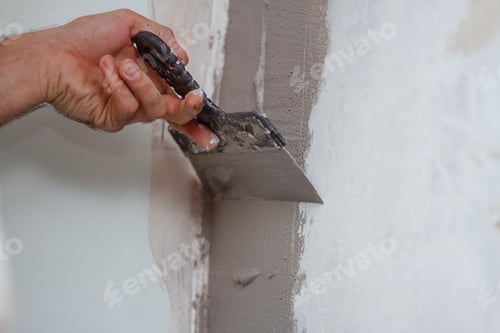 Preview: Person Smoothing Cement on a Light Gray Wall