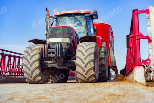 Preview: Modern red agricultural tractor in a farm