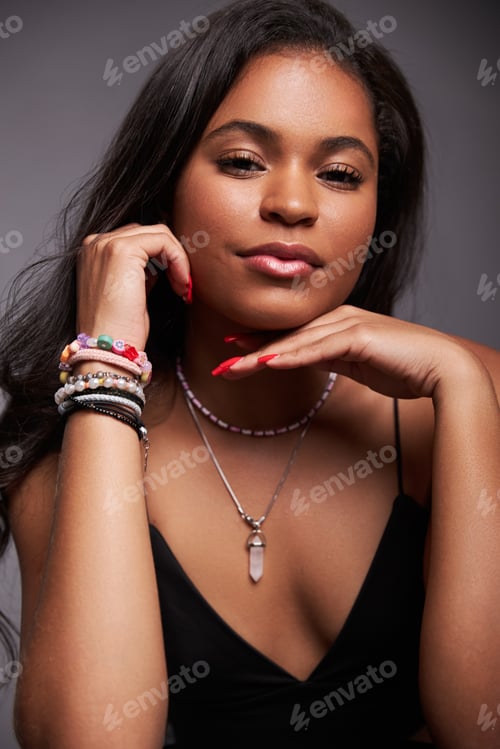 Preview: Self assured young ethnic lady touching chin and looking at camera
