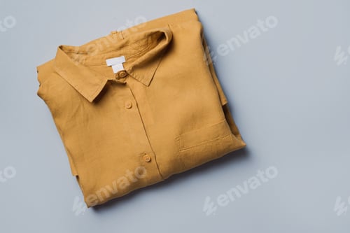 Preview: Folded Yellow Shirt on Pale Background