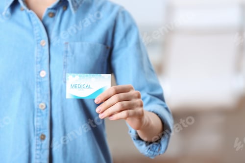 Preview: Woman holding business card indoors, closeup with space for text. Medical service