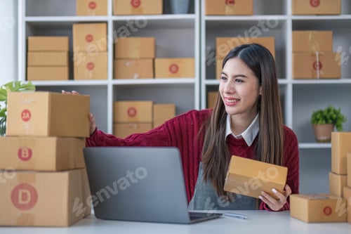 Preview: Startup small business entrepreneur SME, asian woman packing cloth in box. Portrait young Asian