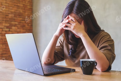 Preview: A woman get headache and stressed while working online on laptop computer at home