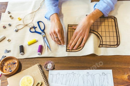 Preview: cropped image of seamstress marking pattern with piece of chalk