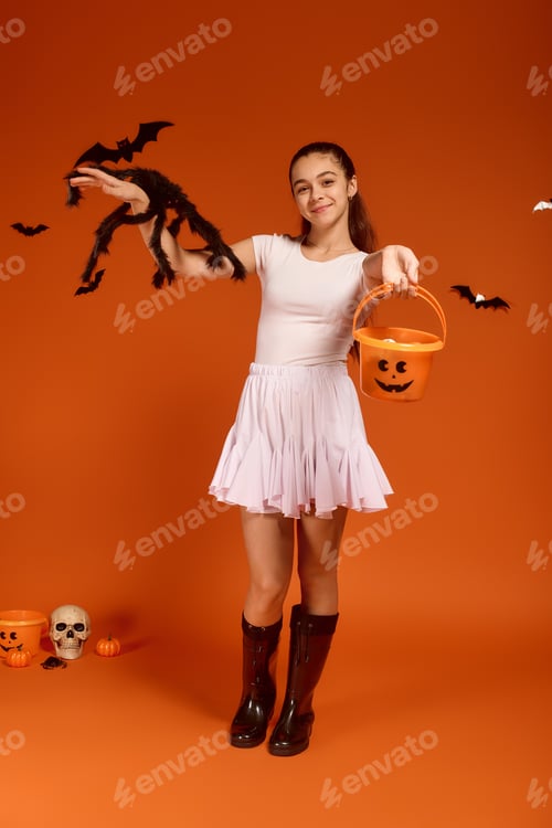 Preview: Cute girl celebrates Halloween with spooky decor on an orange background