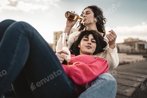 Preview: A young brunette woman lying on her girlfriend's legs looks at the camera
