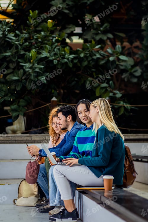 Preview: Diverse group of student siting in campus learning together.
