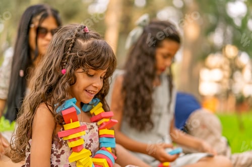 Preview: Happy little girl playing with colorful toy blocks