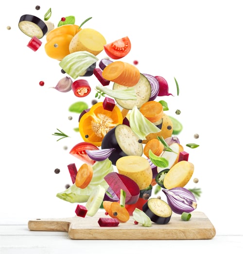 Preview: Vegetables falling onto wooden chopping board, isolated on white background