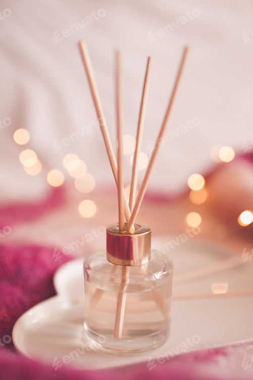 Preview: Liquid home fragrance with aroma sticks in glass bottle closeup. Home refreshment.