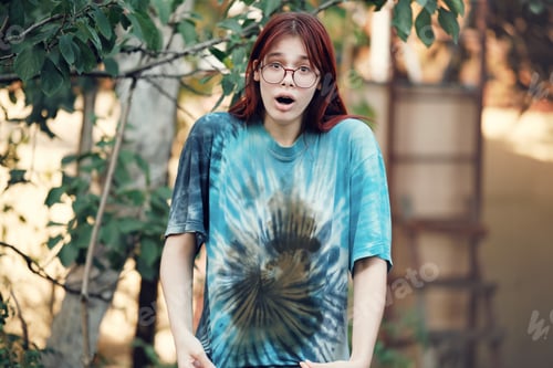 Preview: Shocked red-haired teenage girl with glasses shows a dirty T-shirt.