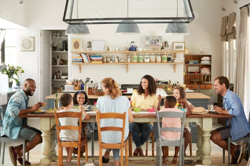 Preview: Two families having lunch together in the kitchen at home