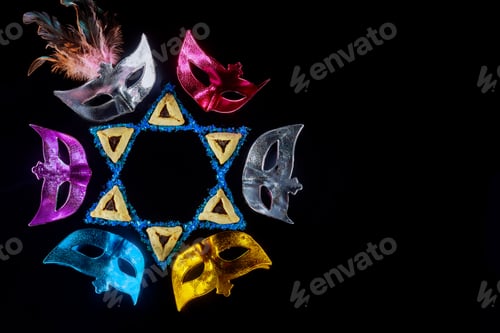 Preview: The Purim Jewish holiday celebrated with Hamantaschen cookies hamans ears and masquerade masks.