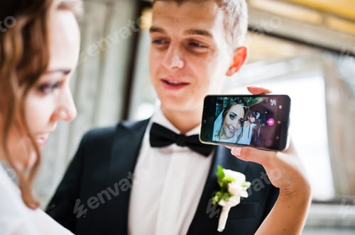 Preview: Wedding couple doing selfie on phone