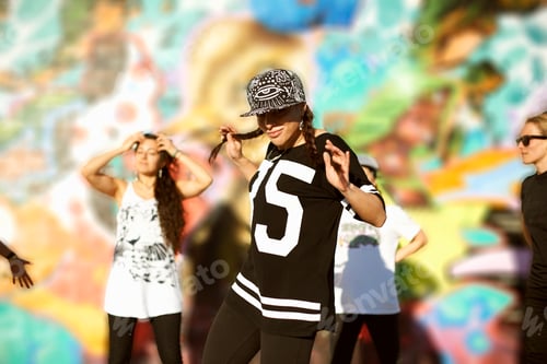 Preview: Young women holding pigtails, wearing baseball cap, looking at camera