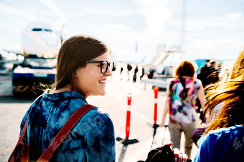 Preview: Happy businesswoman moving towards airplane at terminal
