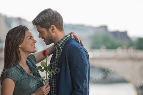Preview: A couple hugging and gazing into each other's eyes. A woman holding a red rose.