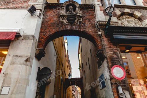 Preview: low angle view of arches and narrow street with old houses in brugge, belgium