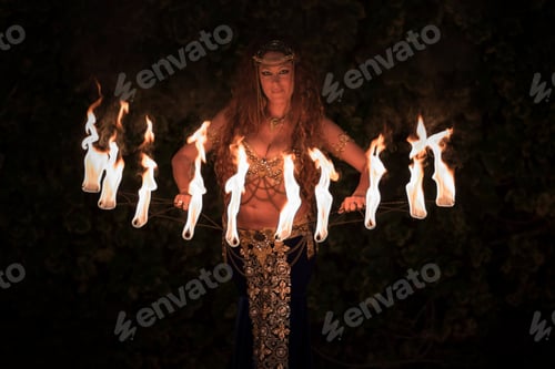 Preview: Attractive Caucasian female in a costume posing with fire fans