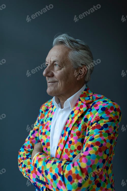 Preview: Senior businessman wearing colorful sports jacket looking away