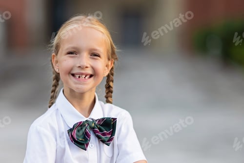 Visualização: Colegial de volta às aulas após as férias de verão. Criança de uniforme sorrindo de manhã cedo ao ar livre.
