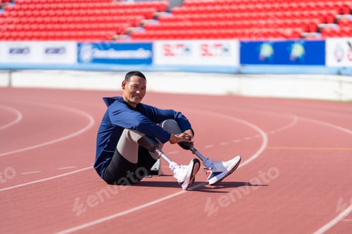 Preview: Asian para-athletes with prosthetic blades sprint on a running track at stadium.
