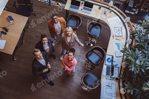 Preview: Group of coworkers standing at office and looking up at camera. Workplace and cooperation concept