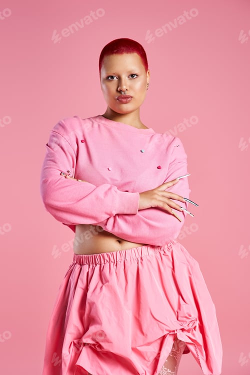 Preview: A young woman with striking pink hair embraces bold fashion in a vibrant studio setting
