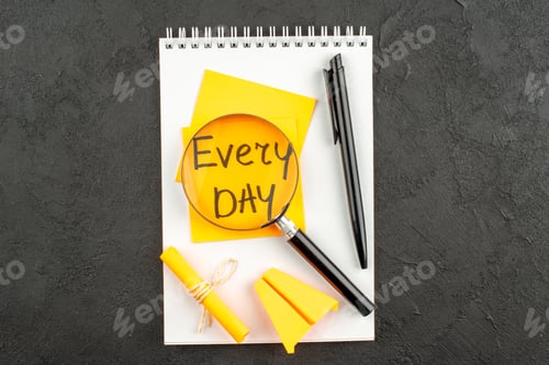 Preview: top view lupa on every day written on sticky note pen scroll sticky note on spiral notebook on dark