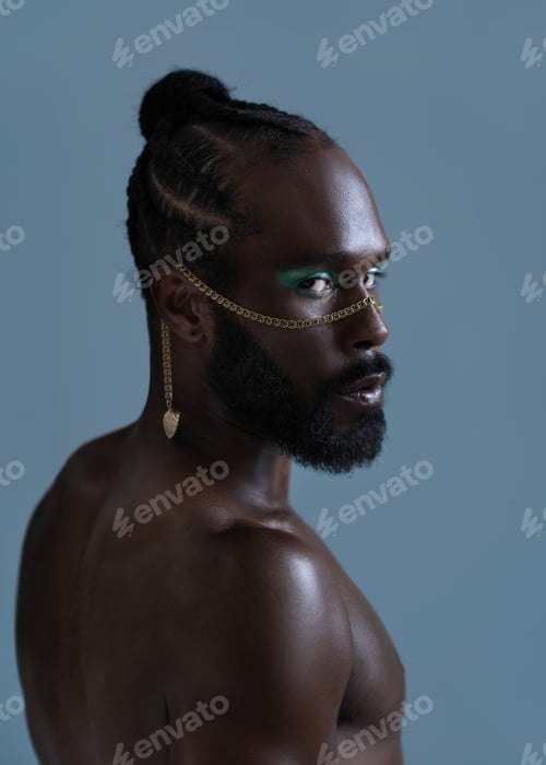 Preview: Serious black shirtless gay man with bright makeup and gold accessory on face