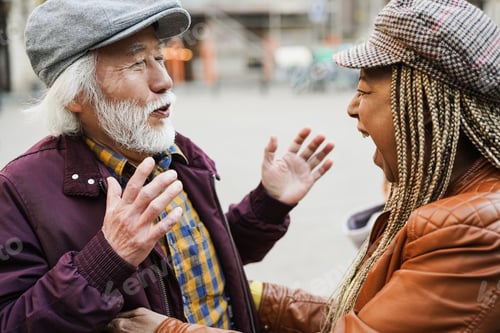 Preview: Multiracial senior friends having fun greeting each other outdoor - Soft focus on woman mouth