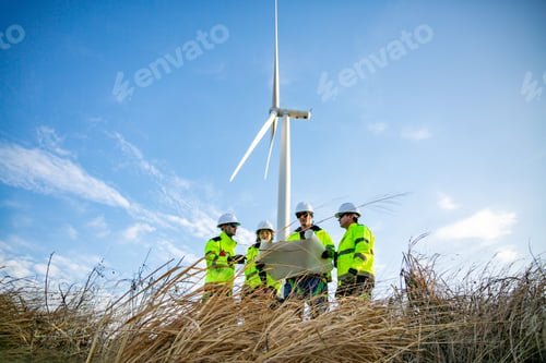 Preview: Team discusses wind turbine project near grass area under clear sky