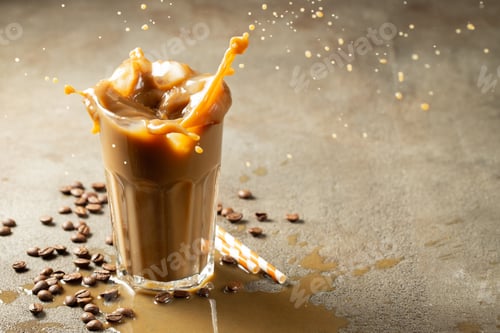 Preview: Iced latte coffee splash with ice cubes and roasted beans on a dark background. With copy space