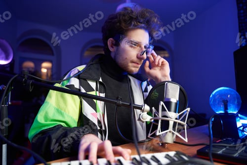 Preview: Professional musician hipster with glasses playing music on computer