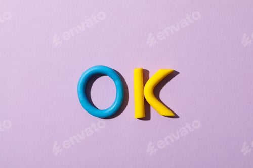 Preview: The word: "ok", laid out from colored plasticine on a purple background.