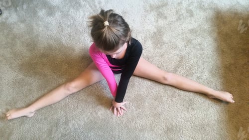 Preview: Overhead shot of generation z girl practicing her gymnastics routine at home for fitness.
