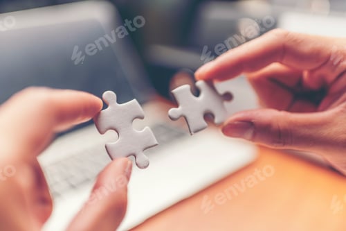 Preview: Cropped hands of businessmen joining jigsaw pieces