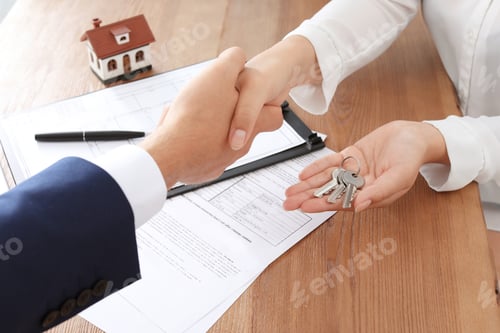 Preview: Woman shaking hands with real estate agent in office, closeup