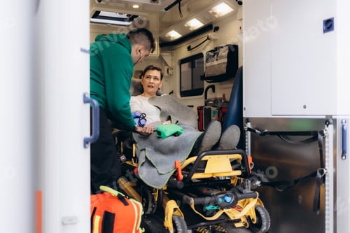 Preview: Medics with injured patient giving an infusion . Young male paramedics holding iv solution