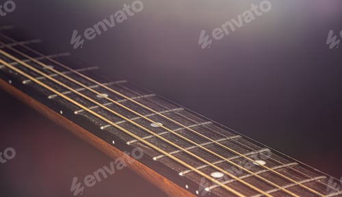 Preview: Close-up of strings on the fretboard of an acoustic guitar.